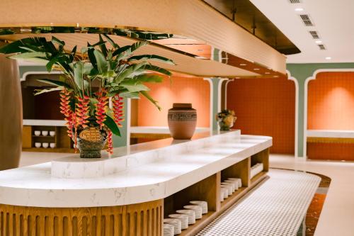 a lobby with a counter with a plant on it at Soc Village Wellness & Retreat in Sóc Sơn