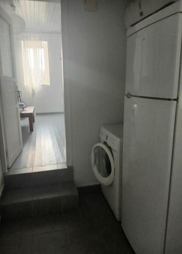 a small bathroom with a refrigerator and a washing machine at Beautiful house ideal for families in Varos