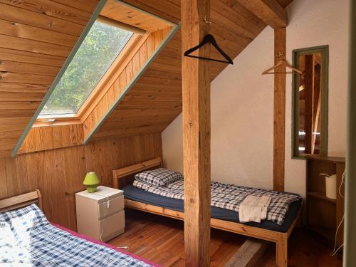 a bedroom with two beds in a wooden cabin at Denderi in Vaidava