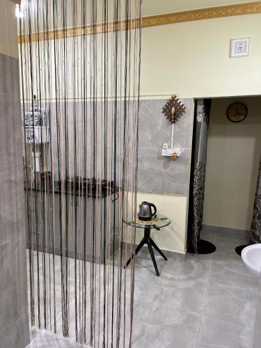 a bathroom with a shower with a sink and a table at Cozy Prime Private Service Apartment in Bangalore in Bengaluru