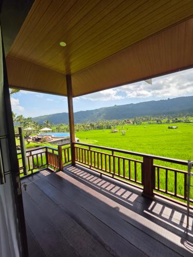 a porch with a view of a green field at MAYURA BALI VILLA in Munduk