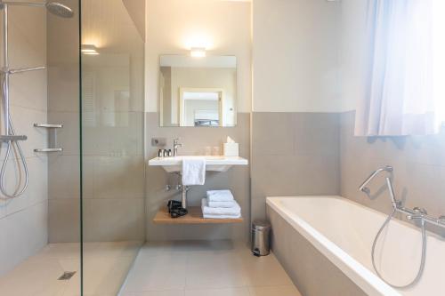 a bathroom with a tub and a sink and a shower at HuysHoeve in Knokke-Heist