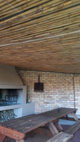 a wooden table in a room with a brick wall at Sunshine Lodge in Jeffreys Bay