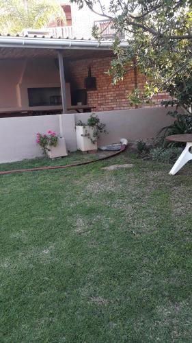 a yard with potted plants on the side of a house at Sunshine Lodge in Jeffreys Bay
