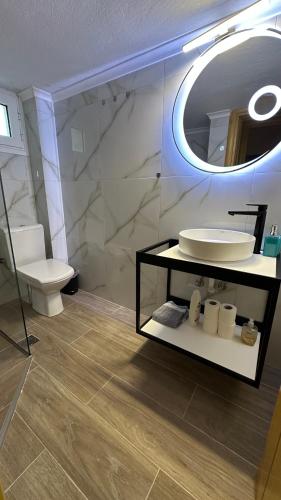 a bathroom with a sink and a toilet and a mirror at Elena apartment chalkidiki in Kallithea Halkidikis