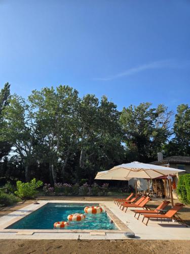 une piscine avec des chaises longues et un parasol dans l'établissement CASA ALENTI - Maison d'Hôtes, à Beaumes-de-Venise