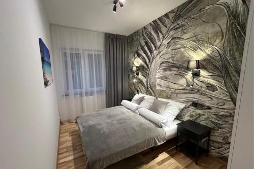 ein Schlafzimmer mit einem Bett und einem Wandbild in der Unterkunft Apartment Paradise in Świnoujście