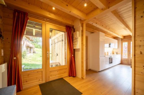 - une chambre avec une grande fenêtre dans une maison en bois dans l'établissement La Grange d'Anaïs, à Beaufort