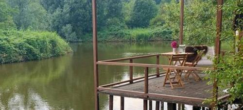 a table and chairs on a dock over a river at Landgoed Vidaa in Bergschenhoek