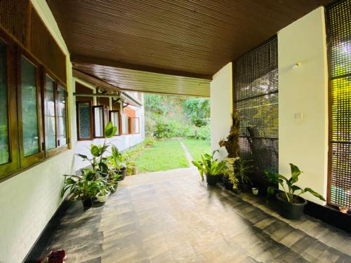 a hallway of a house with plants and windows at Steps Kandy in Kandy