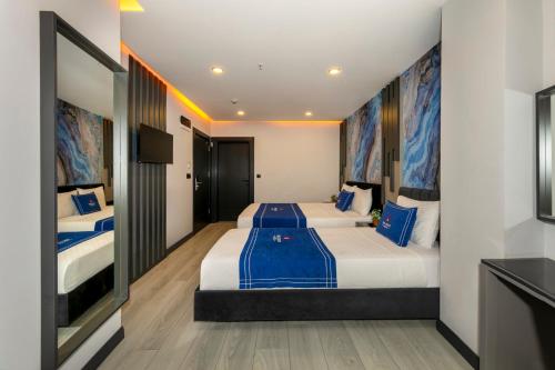 a hotel room with two beds and a tv at The Great Airport Hotel in Arnavutköy