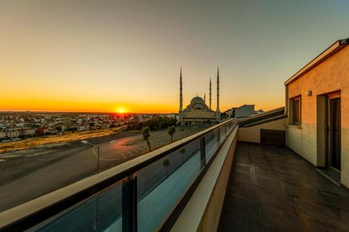a view of the sunset from the balcony of a building at The Great Airport Hotel in Arnavutköy