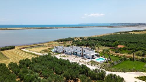 an aerial view of a house on a hill next to the water at Flamingo Living Halkidiki - The Villas in Áyios Mámas