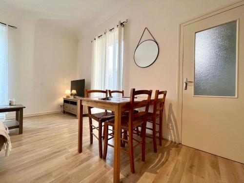 une salle à manger avec une table, des chaises et un miroir dans l'établissement Villa Coquette Plein centre, Proche plage, à Menton