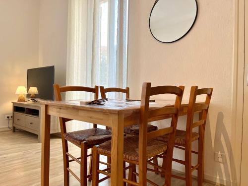 - une table à manger avec 4 chaises et un miroir dans l'établissement Villa Coquette Plein centre, Proche plage, à Menton