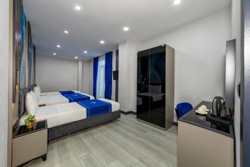 a bedroom with a bed and a desk with a television at The Great Airport Hotel in Arnavutköy