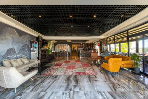 a lobby with couches and chairs on a rug at The Great Airport Hotel in Arnavutköy