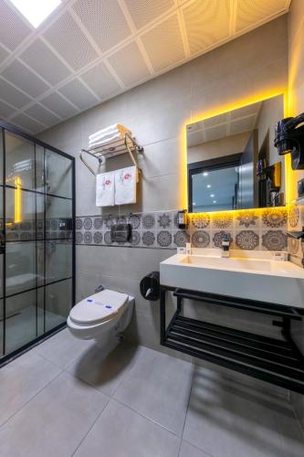 a bathroom with a toilet and a sink and a mirror at The Great Airport Hotel in Arnavutköy