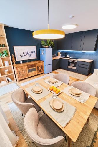 a kitchen and dining room with a wooden table and chairs at JASMIN HOME Apartments in Vítkovice