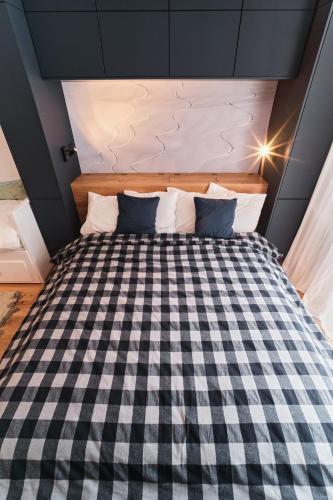 a bedroom with a checkered bed in a room at JASMIN HOME Apartments in Vítkovice