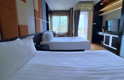 a hotel room with two beds and a television at The Sunreno Hotel Bangkok in Bangkok