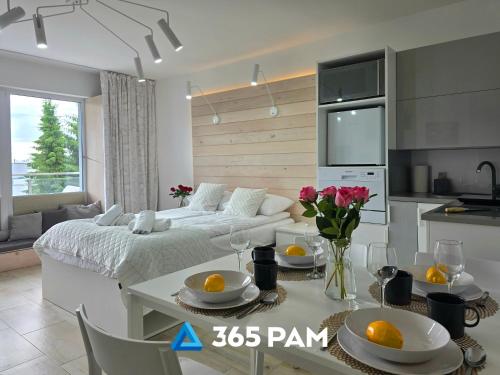 - un salon avec un lit et une table avec des oranges dans l'établissement 365PAM - Studio Białe i Czarne w Dominikanie Przy Morzu, à Sianożęty