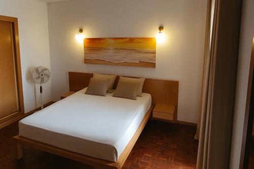 a bedroom with a bed and a painting on the wall at Casa TIANA in Mindelo