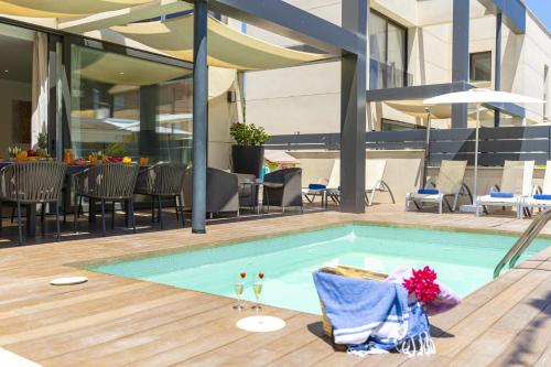 a swimming pool with chairs and tables on a building at Villa Jade I in Can Picafort