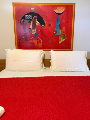 a bed with two pillows and a painting above it at Villa Francesca Pomezia Roma in Pomezia