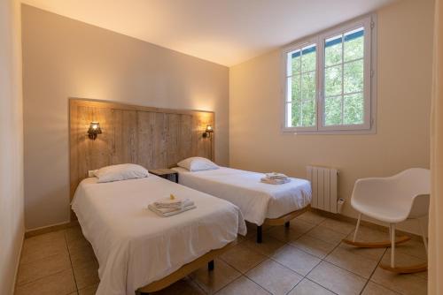 a room with two beds and a window at Les Collines Iduki in Labastide-Clairence