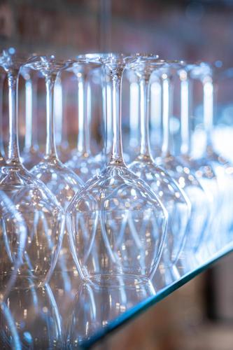 a row of wine glasses sitting on a shelf at HuysHoeve in Knokke-Heist