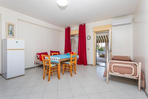 a kitchen with a table and chairs in a room at I Ciottoli Dello Ionio in Mascali