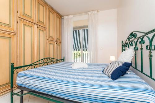 a bedroom with a bed with blue and white sheets at I Ciottoli Dello Ionio in Mascali