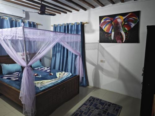 a bedroom with a bed with a canopy at COCO JAMBO PARADISE Beach in Uroa
