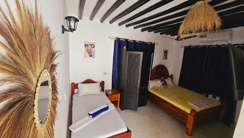 a bedroom with two beds and a palm tree at COCO JAMBO PARADISE Beach in Uroa