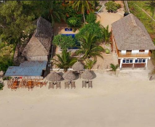 an aerial view of a resort with tables and chairs on the beach at COCO JAMBO PARADISE Beach in Uroa