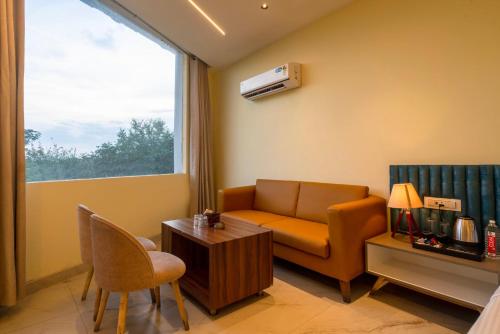 a living room with a couch and a window at Treebo The Mountain Deer Valley Near PGI in Chandīgarh