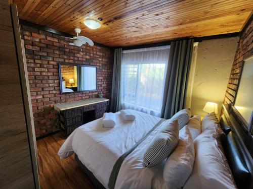 una camera da letto con un letto e un muro di mattoni di Addo Bush & Bay Cottage a Gqeberha