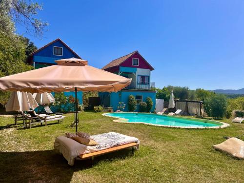 a house with an umbrella and a swimming pool at Apartamentos la Jayma del Arte in Asque