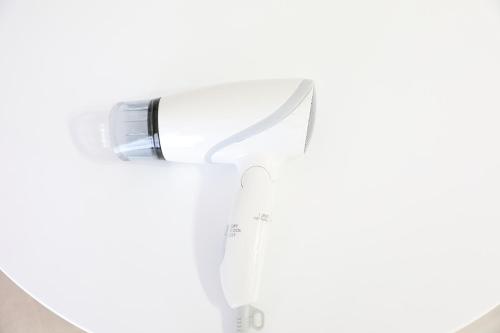 a white hairdryer sitting on top of a mirror at シティラデファンス - 2025年6月室内リニューアル in Sapporo