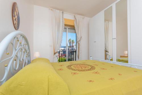 a bedroom with a yellow bed and a balcony at I Ciottoli Dello Ionio in Mascali