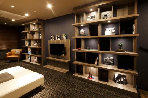 a living room with a large book shelf at HOTEL MYSTAYS PREMIER Kanazawa in Kanazawa