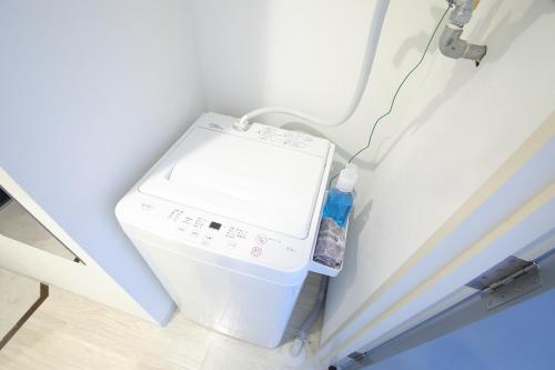 a small refrigerator in a corner of a room at シティラデファンス - 2025年6月室内リニューアル in Sapporo