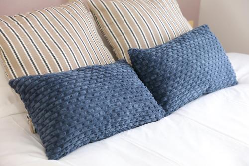 two blue pillows sitting on a white couch at シティラデファンス - 2025年6月室内リニューアル in Sapporo