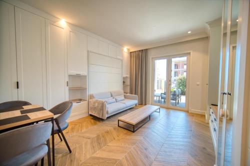 a living room with a couch and a table at Lustica Bay Centrale by 2BHome in Tivat