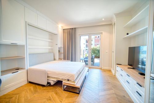 a bedroom with a bed and a flat screen tv at Lustica Bay Centrale by 2BHome in Tivat