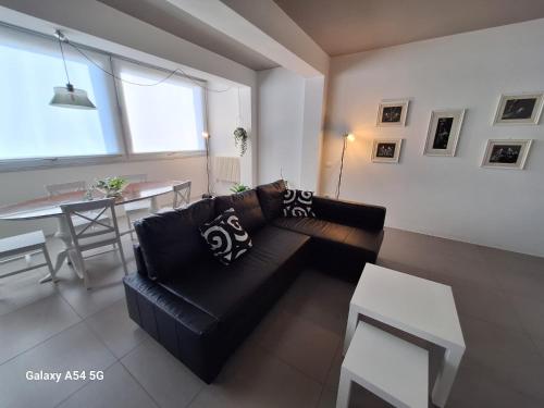 a living room with a black couch and a table at Perla delle Egadi in Marsala