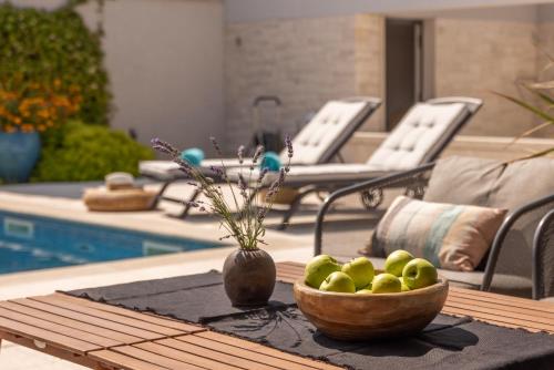 a bowl of apples on a table next to a pool at Villa Amorosa in Nerezine