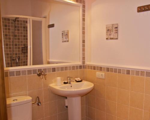a bathroom with a sink and a toilet and a mirror at El balcón de Alange in Alange