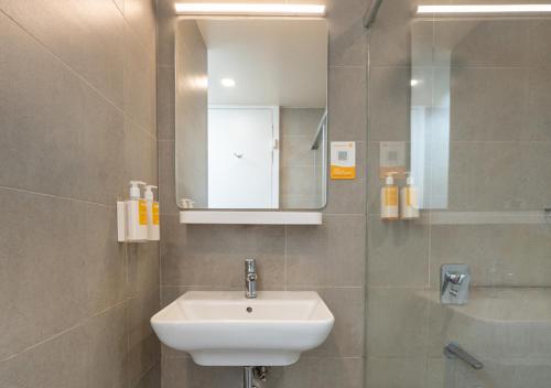 a bathroom with a sink and a mirror at Bloom Hotel - DLF Road Gachibowli in Kondapur